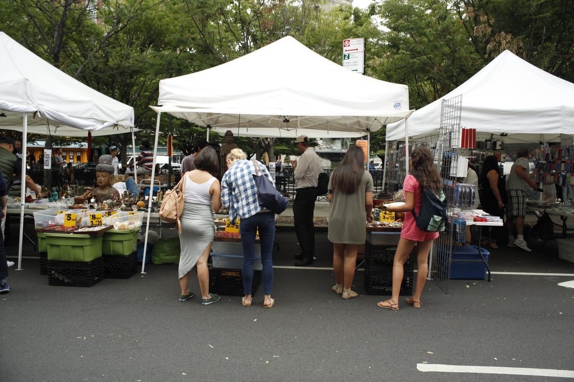 People browsing vendors' tents at 6th Ave Street Fair
